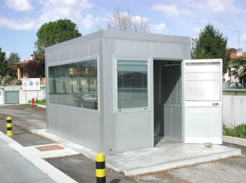 Cabina prefabbricata ad uso ufficio monitoraggio pesa realizzata con pareti lisce e a filo colonne, colore grigio metallizzato e ampie vetrate antisfondamento